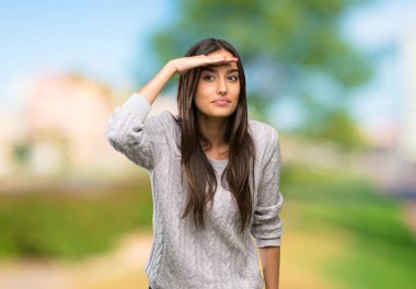 Genç İspanyol esmer kadın, bir şeyler görmek için elleriyle uzaklara bakıyor.