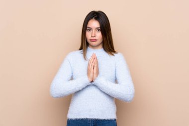 Tecrit edilmiş bir geçmişi olan genç bir kadın avuç içlerini bir arada tutar. İnsan bir şey ister.