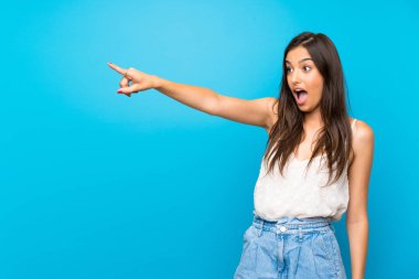 İzole edilmiş mavi arka planda genç bir kadın.