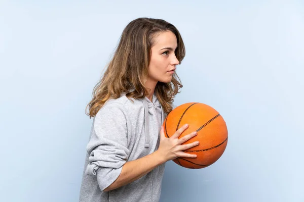 Young blonde woman with ball of basketball