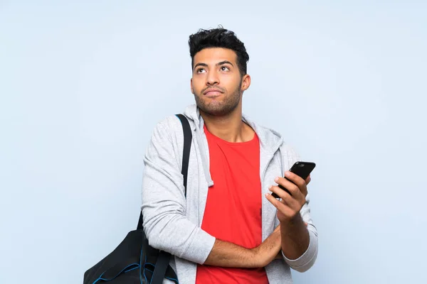 Sportmann Über Isolierter Blauer Wand Macht Zweifel Geste Beim Heben — Stockfoto