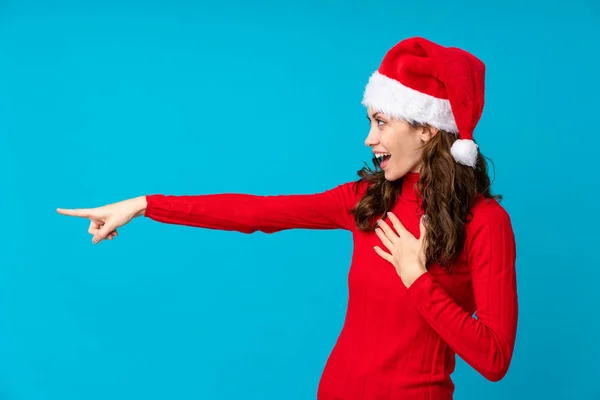 Mädchen Mit Weihnachtsmütze Über Gelbem Hintergrund Zeigt Mit Dem Finger — Stockfoto