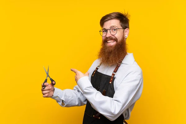 Barbeiro Com Barba Longa Avental Sobre Fundo Amarelo Isolado Apontando — Fotografia de Stock