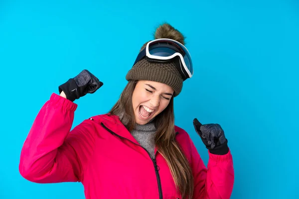 Nastoletnia Narciarka Okularach Snowboardowych Odizolowanym Niebieskim Tle Świętując Zwycięstwo — Zdjęcie stockowe