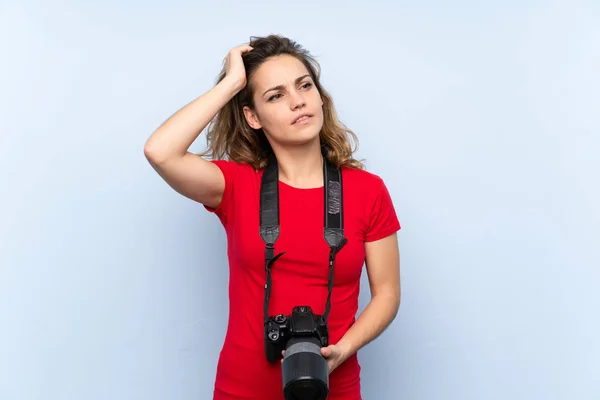 Mujer Rubia Joven Con Una Cámara Profesional Pensando —  Fotos de Stock