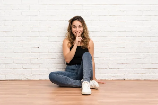 Jovem Loira Sentada Chão Fazendo Gesto Silêncio — Fotografia de Stock