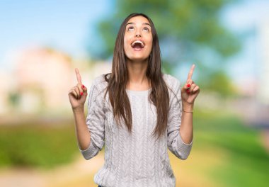 Genç İspanyol esmer kadın şaşırdı ve dışarıyı işaret etti.