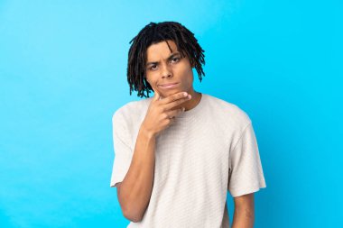 Genç Afro-Amerikalı adam soyutlanmış mavi arka plan düşüncesi