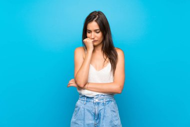 İzole edilmiş mavi arka planı olan genç bir kadın.