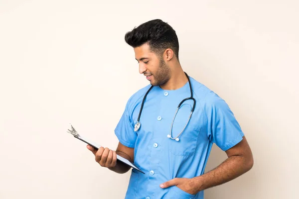 Jovem Homem Bonito Sobre Fundo Isolado Com Vestido Médico Segurando — Fotografia de Stock