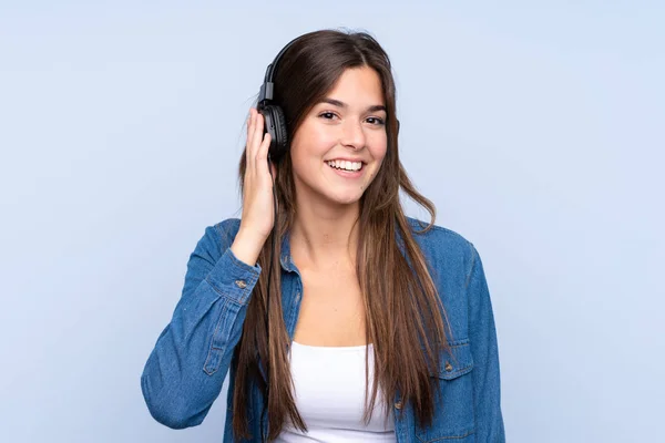 Adolescente menina brasileira ouvindo música sobre isolado azul backg — Fotografia de Stock
