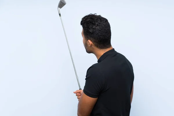 Guapo joven jugando al golf sobre fondo azul aislado — Foto de Stock