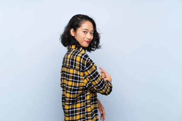 Asyalı Genç Kadın Izole Edilmiş Mavi Arka Plan Geriye Işaret — Stok fotoğraf