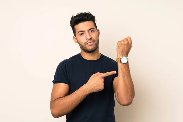 Νεαρός Όμορφος Άνδρας Πάνω Από Απομονωμένη Φόντο Δείχνει Ρολόι Χέρι — Φωτογραφία Αρχείου