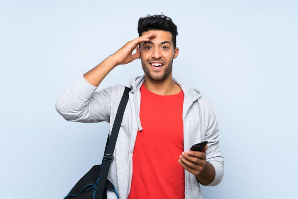 Sportler Über Isolierte Blaue Wand Mit Überraschung Und Schockiertem Gesichtsausdruck — Stockfoto