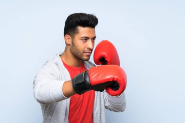 Izole mavi duvar üzerinde boks eldiven ile Spor adam
