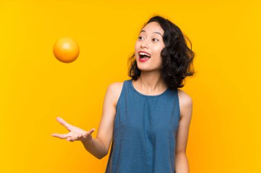 Asyalı genç kadın bir portakal tutan