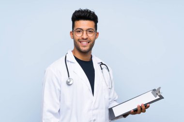 Izole mavi duvar üzerinde genç doktor adam