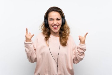 Genç sarışın kadın kulaklık ve dans ile cep telefonu kullanarak