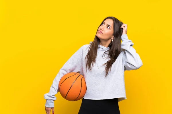 Young Woman Playing Basketball Isolated Yellow Background Having Doubts Confuse — Stock Photo, Image