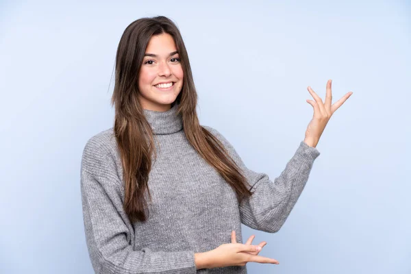 Adolescente Brasileña Chica Sobre Aislado Fondo Azul Extendiendo Las Manos —  Fotos de Stock