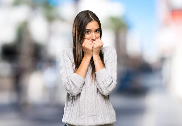 Young hispanic brunette woman nervous and scared putting hands to mouth at outdoors