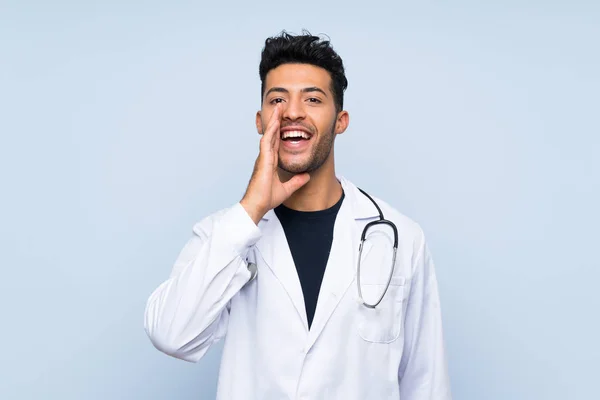 Joven Médico Sobre Aislada Pared Azul Gritando Con Boca Abierta —  Fotos de Stock