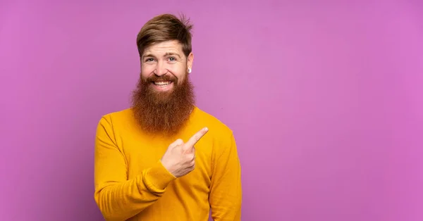 Hombre Pelirrojo Con Barba Larga Sobre Fondo Púrpura Aislado Apuntando — Foto de Stock