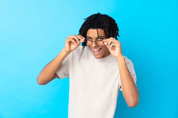 Junger Afroamerikaner Vor Isoliertem Blauen Hintergrund Mit Brille Und Überrascht — Stockfoto