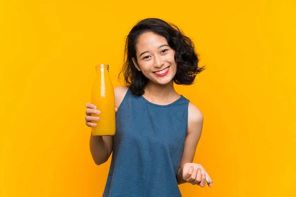 Ασίας νεαρή γυναίκα που κρατά ένα χυμό πορτοκάλι — Φωτογραφία Αρχείου