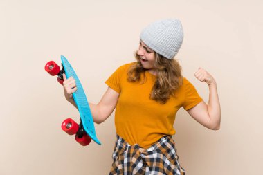 Genç patenci sarışın kız izole arka plan üzerinde bir zafer kutluyor