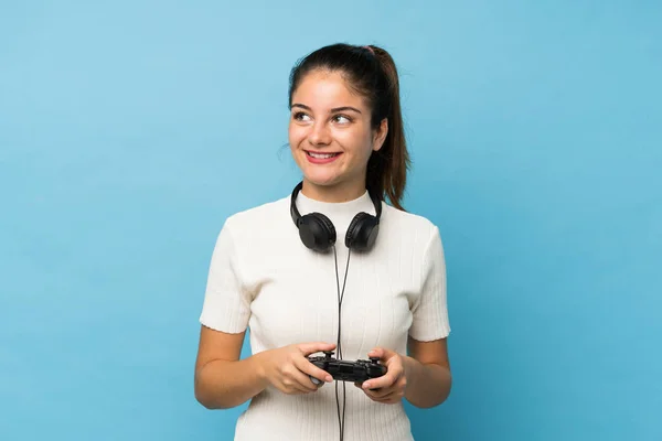 Chica Morena Joven Sobre Fondo Azul Aislado Jugando Videojuegos —  Fotos de Stock