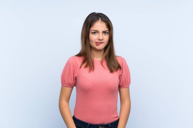 Genç esmer kız, izole edilmiş mavi arka planda kuşkuları ve kafa karıştırıcı bir yüz ifadesi var.