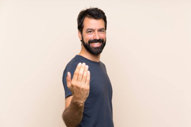 Sakallı bir adam, eli ile gelmeye davet ediyor. Gelmene sevindim.