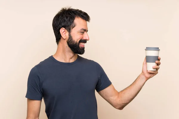 Mężczyzna Brodą Trzymający Kawę Szczęśliwym Wyrazem Twarzy — Zdjęcie stockowe
