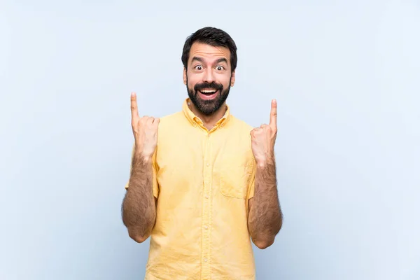 Joven Con Barba Sobre Fondo Azul Aislado Apuntando Una Gran —  Fotos de Stock