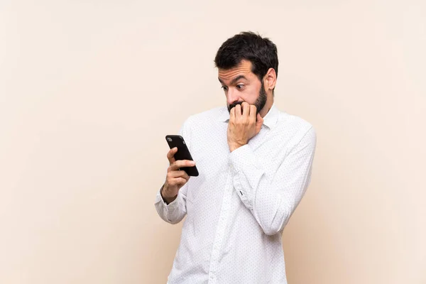 Joven Con Barba Sosteniendo Móvil Nervioso Asustado Poniendo Las Manos —  Fotos de Stock