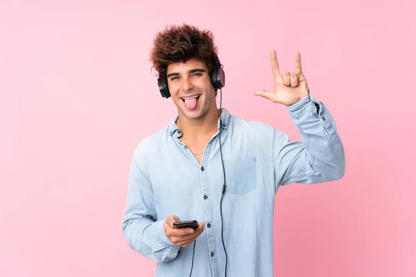 Νεαρός Καυκάσιος Πάνω Από Απομονωμένο Ροζ Φόντο Χρησιμοποιώντας Κινητό Ακουστικά — Φωτογραφία Αρχείου