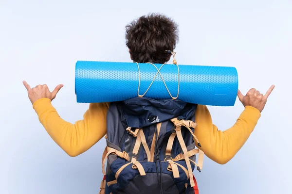 Jeune alpiniste homme avec un grand sac à dos sur isolé bleu bac — Photo