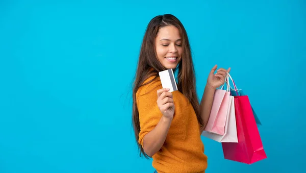 Jong Braziliaans Meisje Geïsoleerde Blauwe Achtergrond Holding Boodschappentassen Een Creditcard — Stockfoto