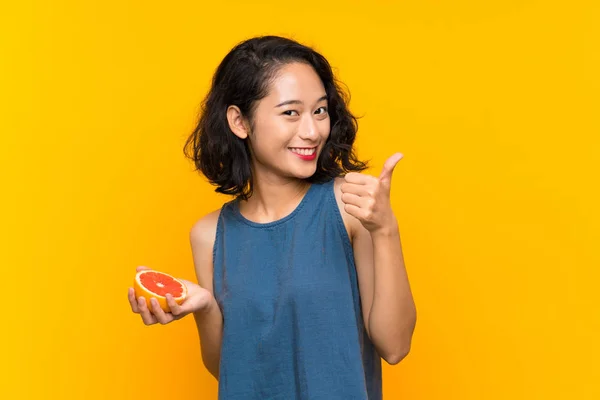 Young Asian Girl Holding Grapefruit Isolated Orange Background Thumbs Because — Stockfoto