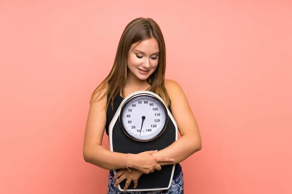 Menina adolescente com máquina de pesagem sobre fundo isolado — Fotografia de Stock