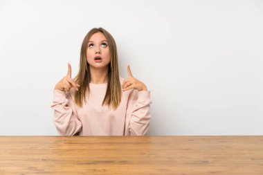 İşaret parmağı ile işaret bir masada Genç kız harika bir fikir