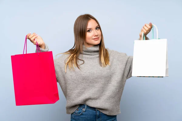 Tiener Meisje Met Trui Geïsoleerde Blauwe Achtergrond Houden Veel Boodschappentassen — Stockfoto