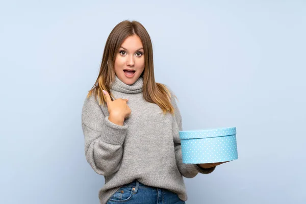 Menina Adolescente Com Suéter Sobre Fundo Azul Isolado Segurando Caixa — Fotografia de Stock