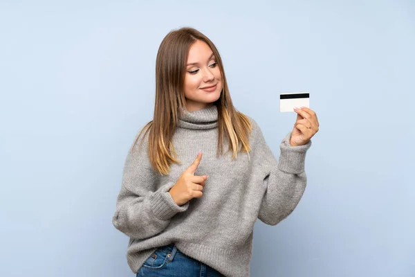 Chica Adolescente Con Suéter Sobre Fondo Azul Aislado Sosteniendo Una — Foto de Stock