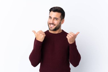 Sakallı yakışıklı bir genç, soyutlanmış beyaz bir geçmişi var. Baş parmakları havada ve gülümsüyor.