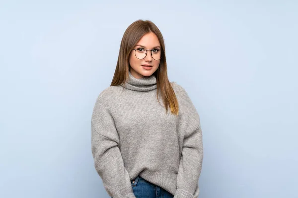 Chica Adolescente Con Suéter Sobre Fondo Azul Aislado Con Gafas —  Fotos de Stock