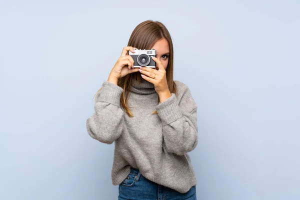 Tonåring Flicka Med Tröja Över Isolerad Blå Bakgrund Hålla Kamera — Stockfoto