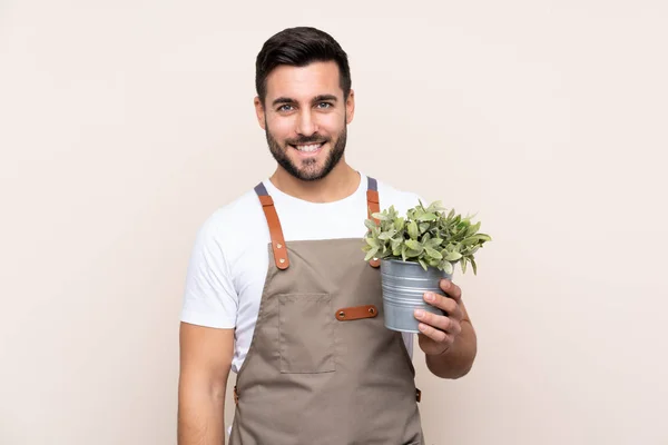 Jardinero Hombre Sosteniendo Una Planta Sobre Aislado Fondo Riendo —  Fotos de Stock